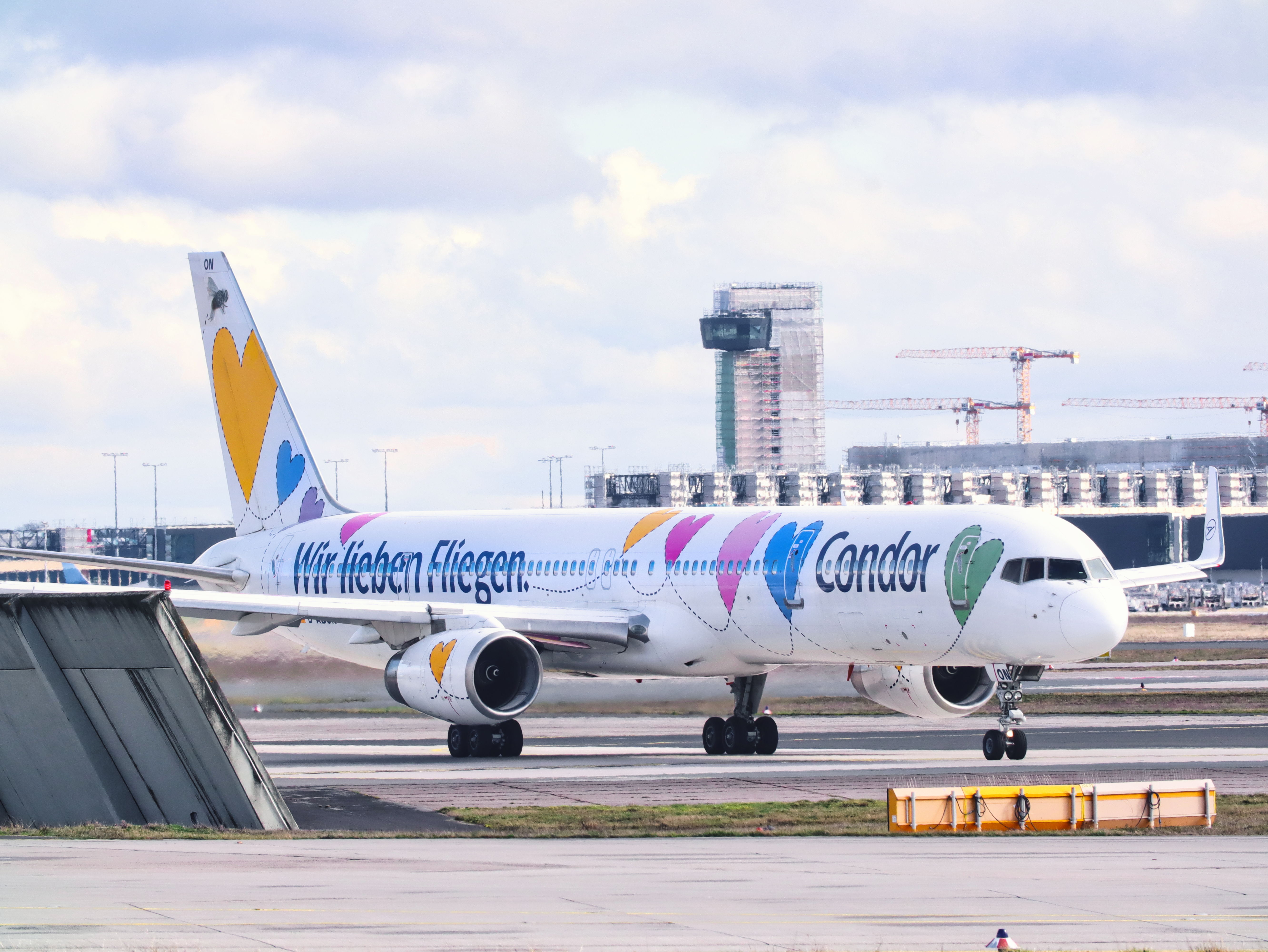 Condor aircraft with special heart livery and the words “We love flying” on the tarmac.